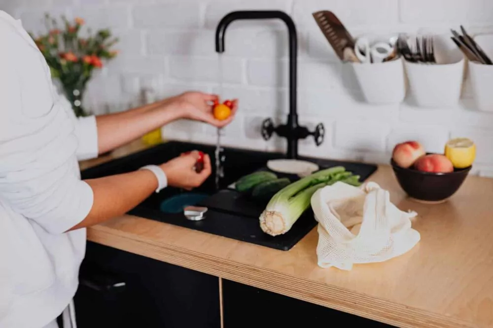 Woman Washing Fresh Ingredients under Tap Water in Kitchen