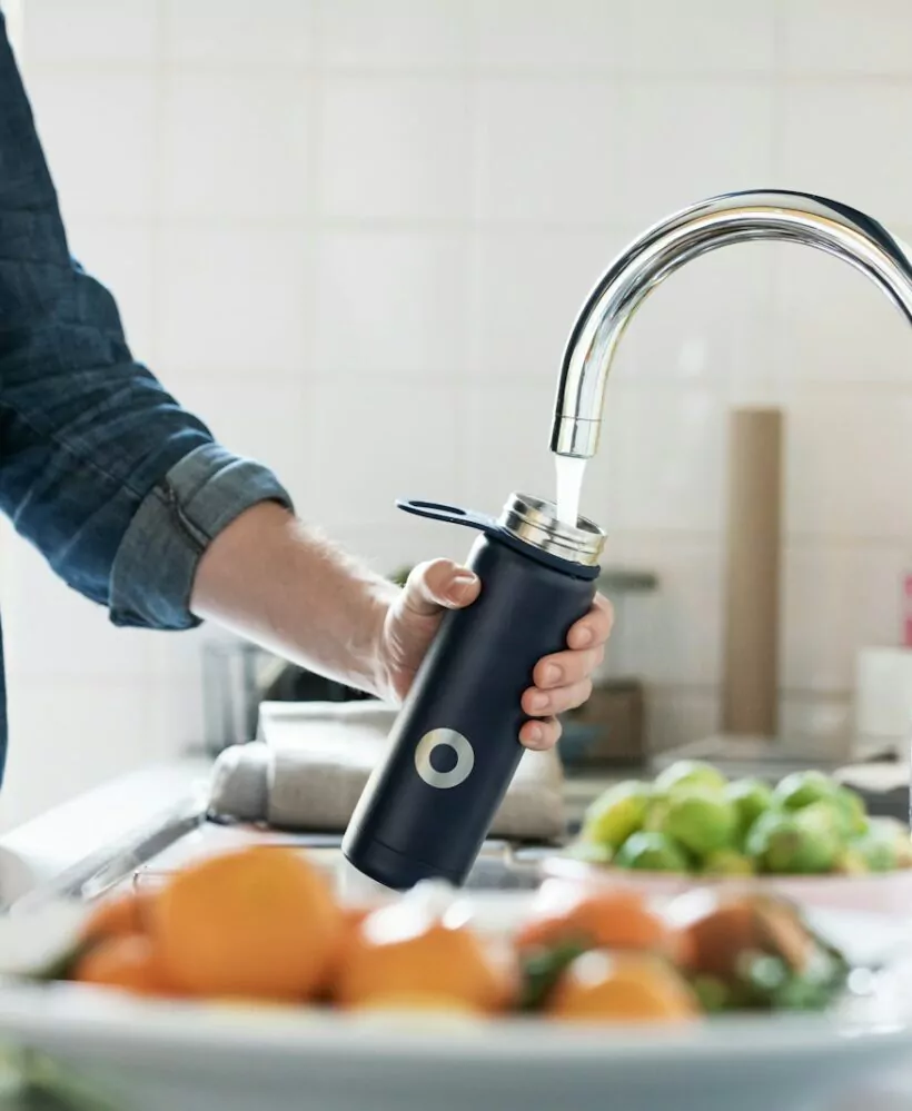 person holding stainless steel faucet