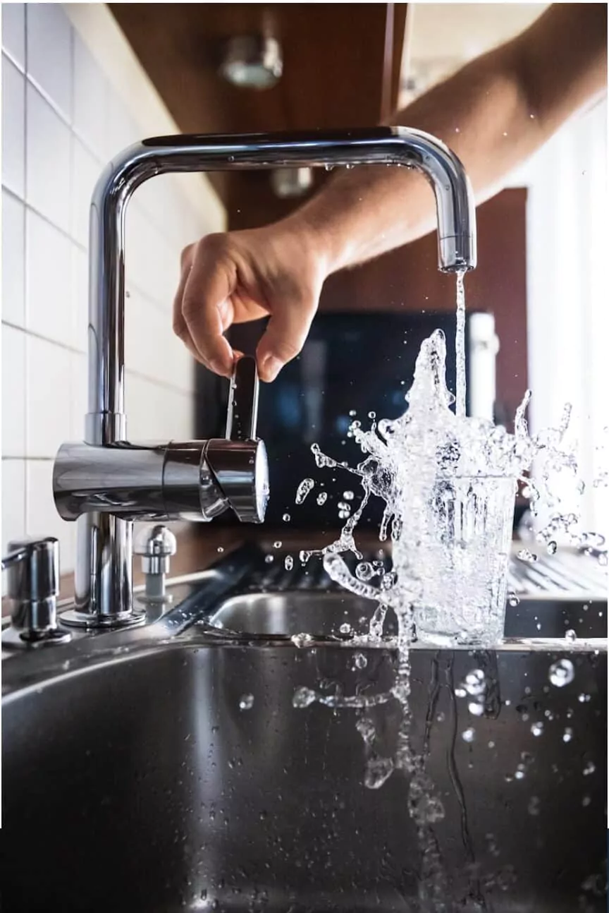 Robinet avec eau qui coule dans un verre